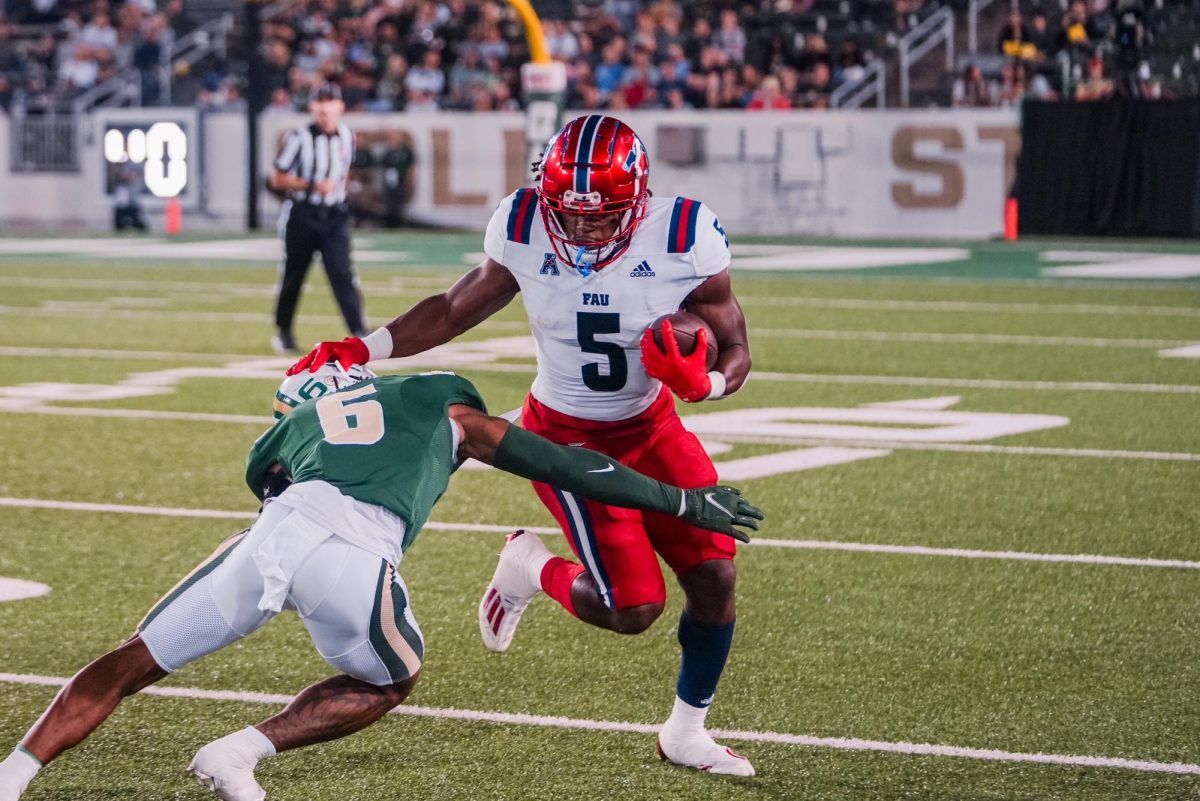 FAU graduate running back Kobe Lewis (#5) avoiding a tackle against Charlotte sophomore defensive back Al-Mahi Ali (#6) during the Owls 38-16 road victory on Friday, Oct. 27, 2023.