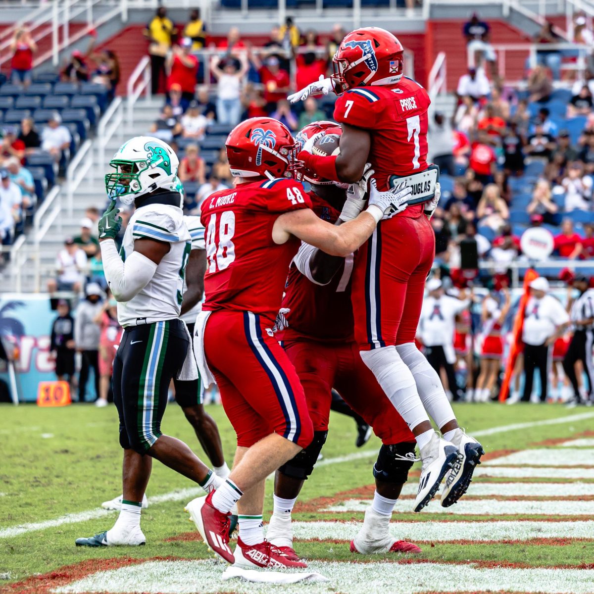 FAU freshman tight end Zeke Moore (#48) and another player celebrating with junior wide receiver Devin Price (#7) after Price caught a pass by junior quarterback Daniel Richardson for a two-point conversion in the fourth quarter. FAU lost their final home game of the season to No. 17 Tulane, 24-8, on Saturday, Nov. 18, 2023.