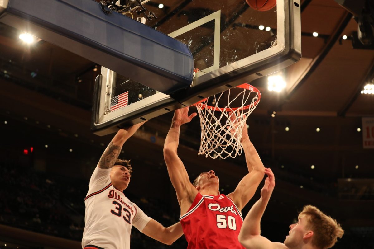 FAU junior center Vlad Goldin (#50) going for a dunk over Illinois senior forward Coleman Hawkins (#33) and another Illinois player during the Owls 98-89 loss to the Fighting Illini in the Jimmy V Classic at Madison Square Garden on Tuesday, Dec. 5, 2023.