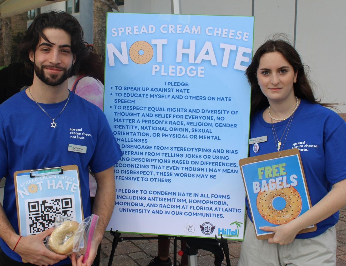 Paul Leachman (Left), Hillel Vice President of Tikkun Olam and Tyler Fokshner, Hillel Vice President of Programming (Right), greet students as they walk the breezeway at FAU to sign the pledges for free bagels and cream cheese. 