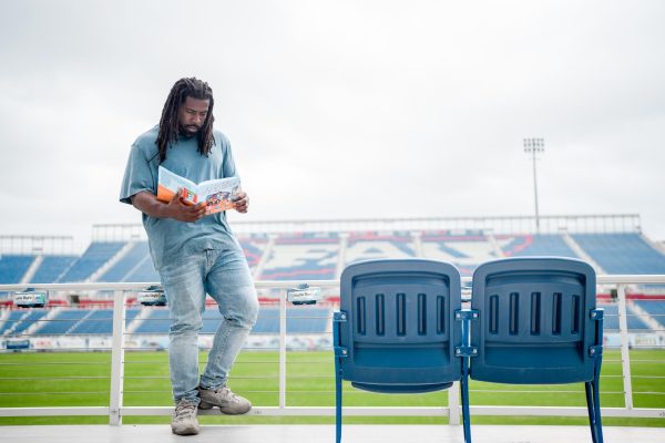 Brandin Bryant at his old stomping grounds, Howard Schnellenberger Field, with his book So, you want to be an athlete?
