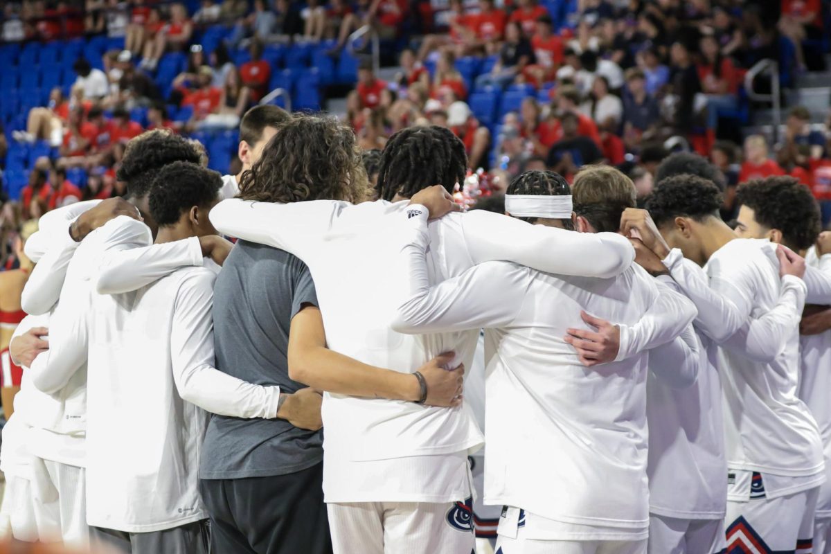 The+2023-2024+Mens+Basketball+roster+huddled+up+during+their+game+against+Tulane%2C+2023.