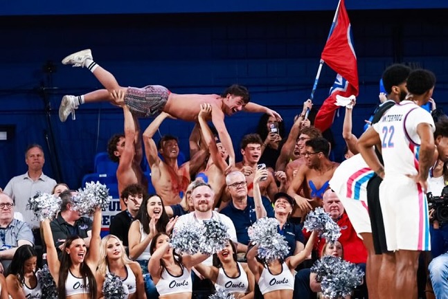 The FAU Swim-and-Dive team holding up one if their teammates to distract FAU men's basketball's opponent while shooting a free throw at the Eleanor R. Baldwin Arena.