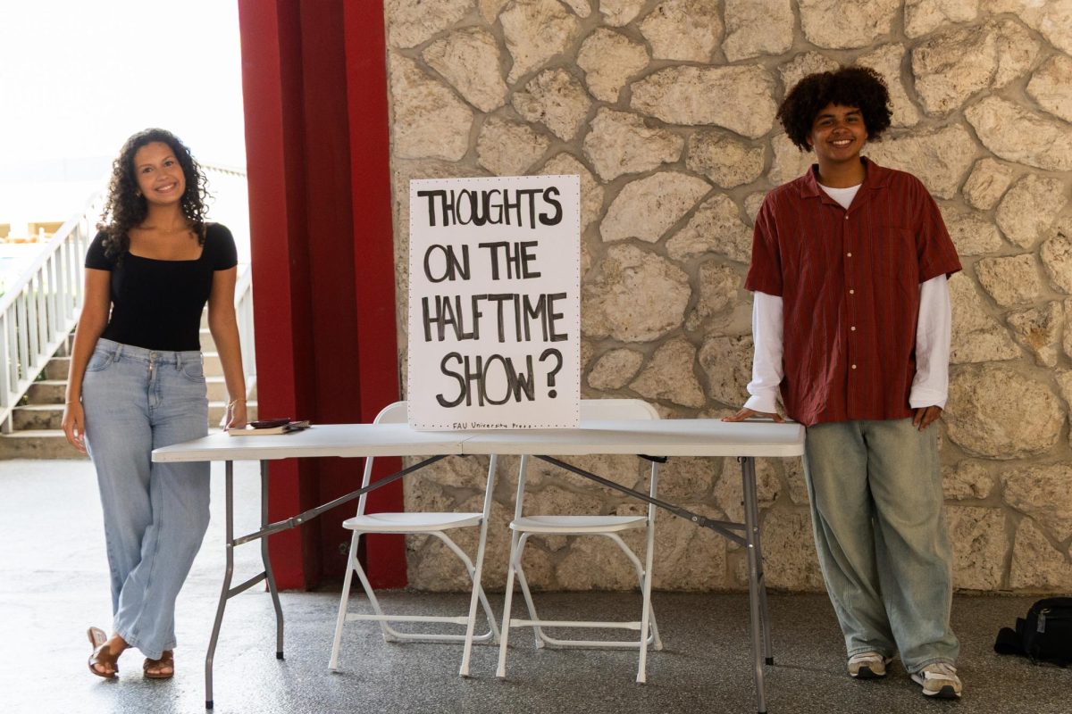 (from left to right) University Press reporters Ana Sofia Barahona and Isaiah Sewell at a tabling event to ask students their thoughts on the Super Bowl LX Halftime Show. 