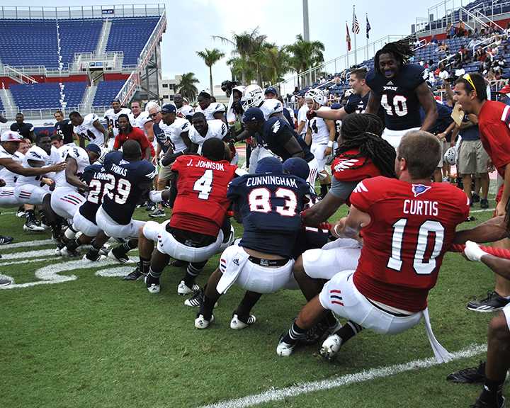 The offensive team and the defensive team battle out in a game of tug-of-war at the end of the spring football game. Photo by Melissa Landolfa.